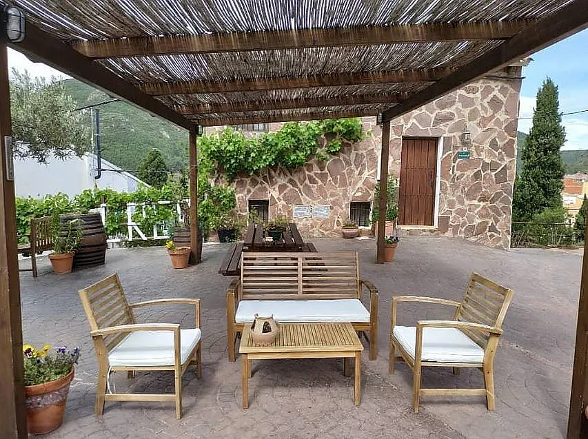 Patio con pérgola y sofás en Les Eres de Gátova
