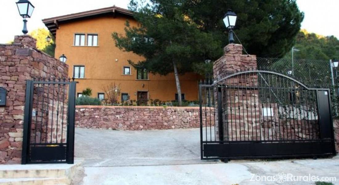 Entrada de piedra y casa de Mas de la Pinaeta